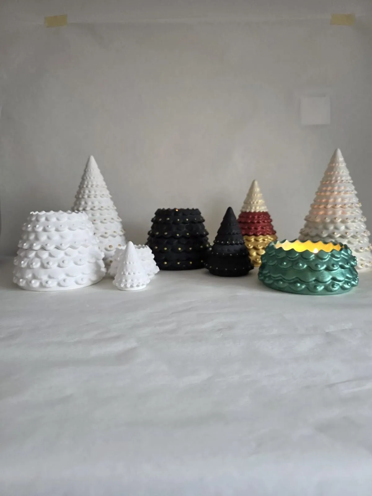 Sculptural holiday tree candles and a teal candle bowl